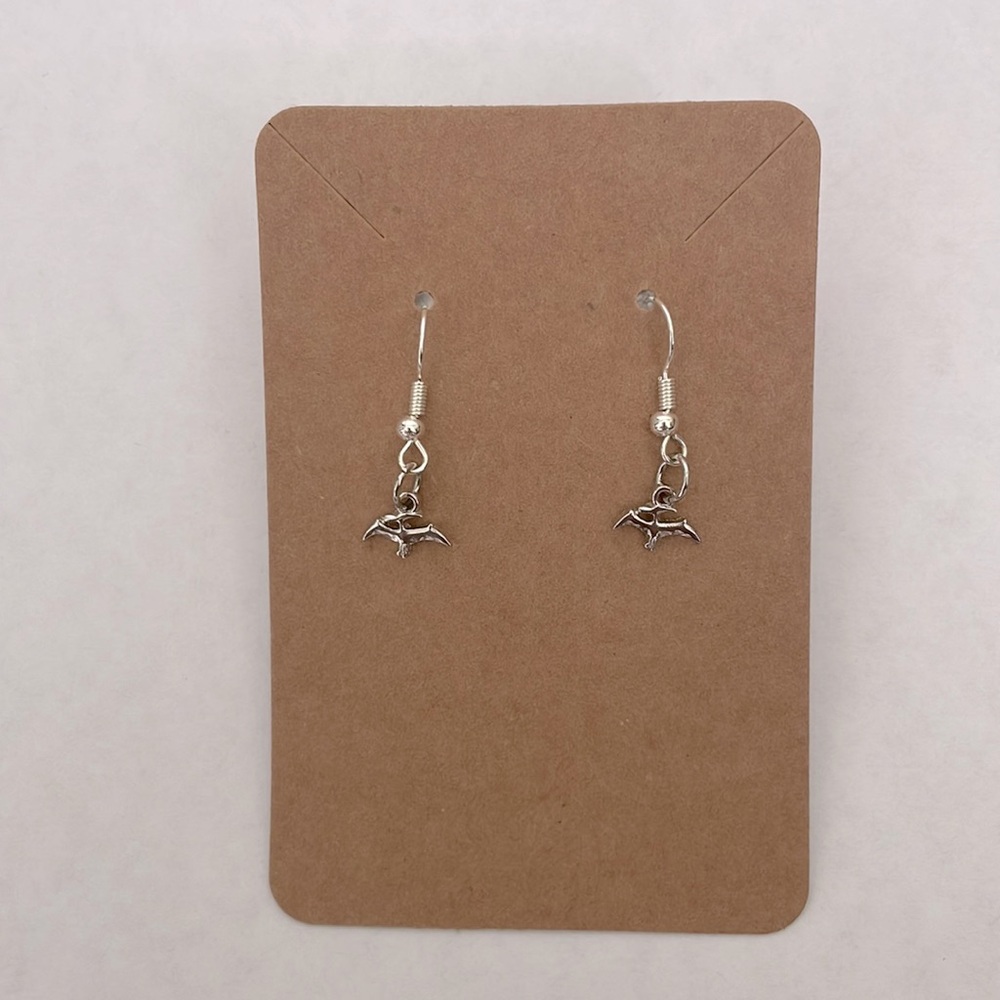 Handmade silver earrings with a dinosaur charm.